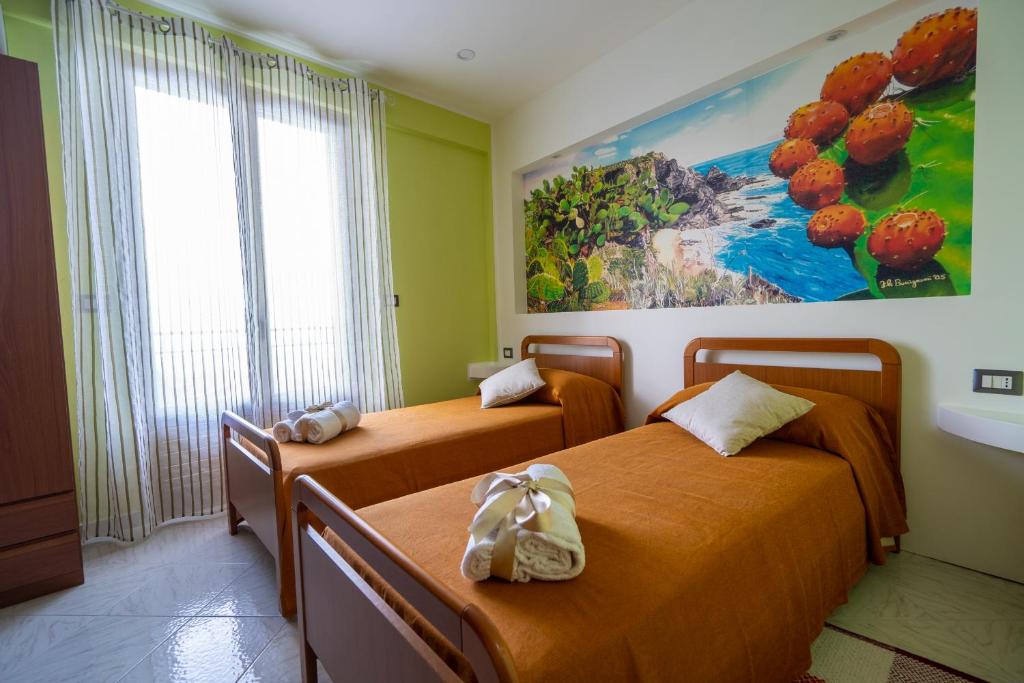 2 Betten in einem Zimmer mit Wandgemälde in der Unterkunft Casa Vacanze dell'Angelo in San Mauro Castelverde