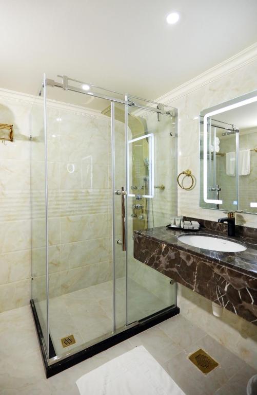 a bathroom with a glass shower and a sink at Ras Al Khaimah Hotel in Ras al Khaimah