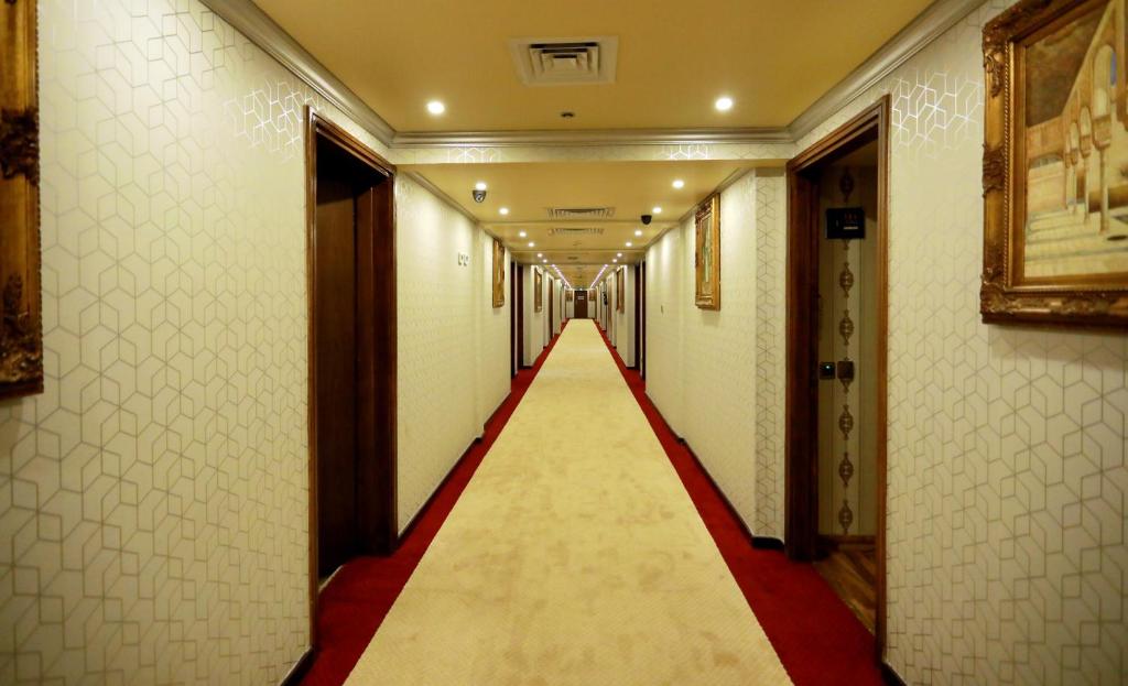a long corridor with a red carpet and a long corridore at Ras Al Khaimah Hotel in Ras al Khaimah