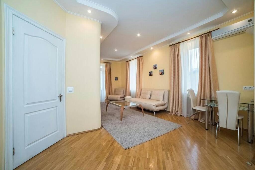 uma sala de estar com uma porta branca e uma mesa e cadeiras em Солнечные апартаменты на Крещатике em Kiev