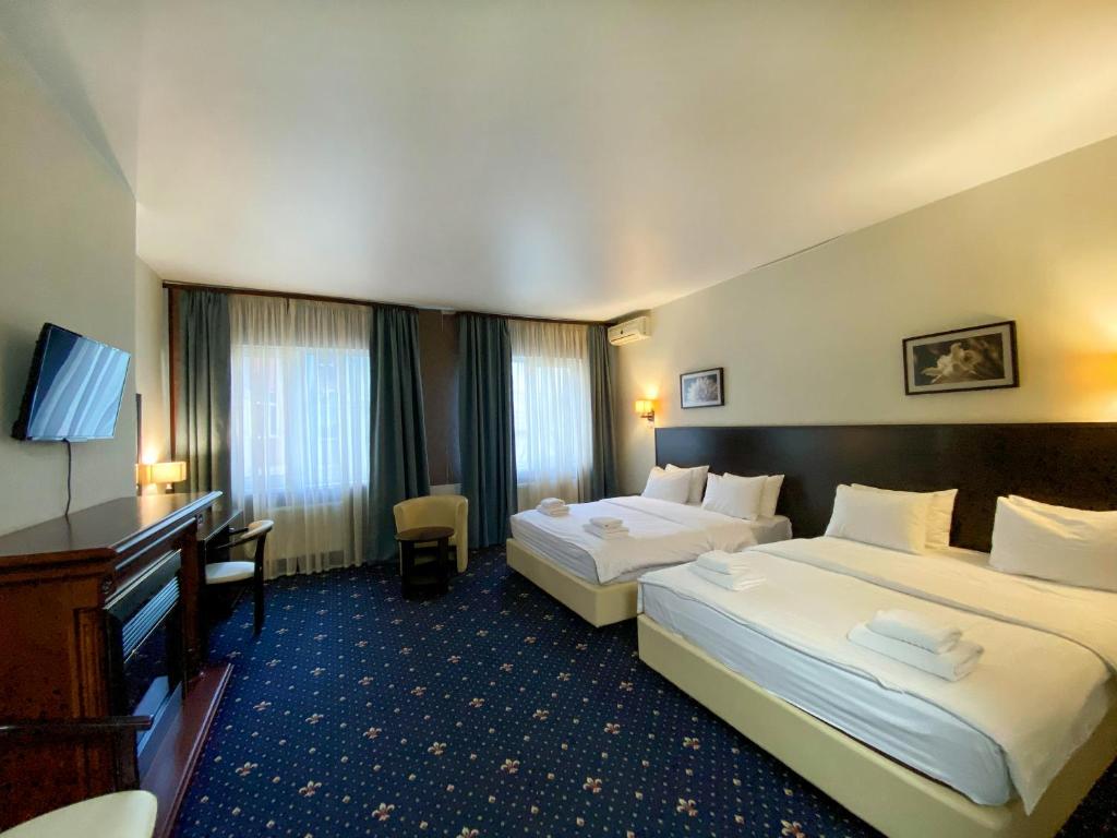 ein Hotelzimmer mit 2 Betten und einem TV in der Unterkunft irisHotels in Kiew