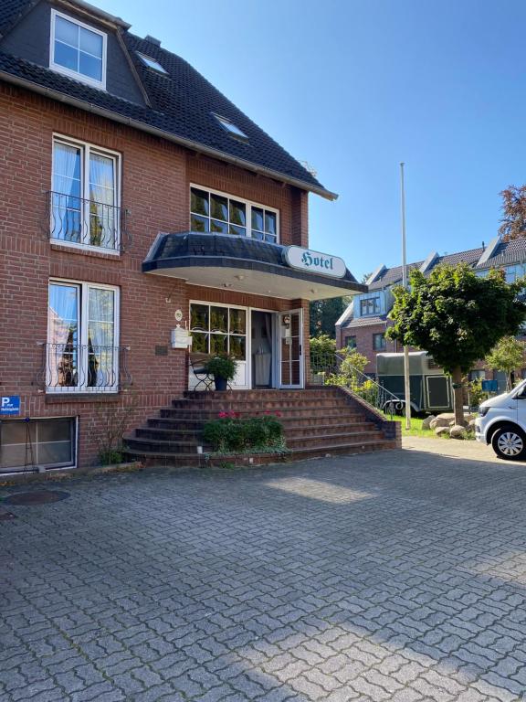 a brick building with stairs leading to the front door at Waldhotel Twiehaus Garni in Lübeck