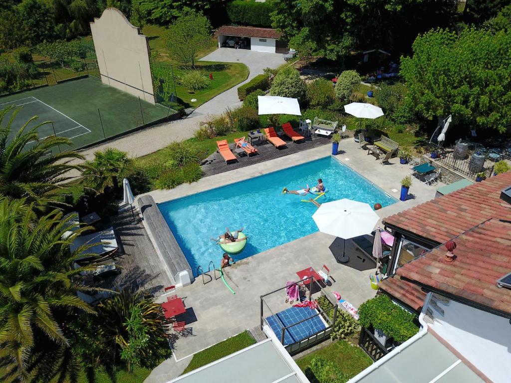 an overhead view of a swimming pool with people playing tennis at Domaine de Millox in Saint-André-de-Seignanx