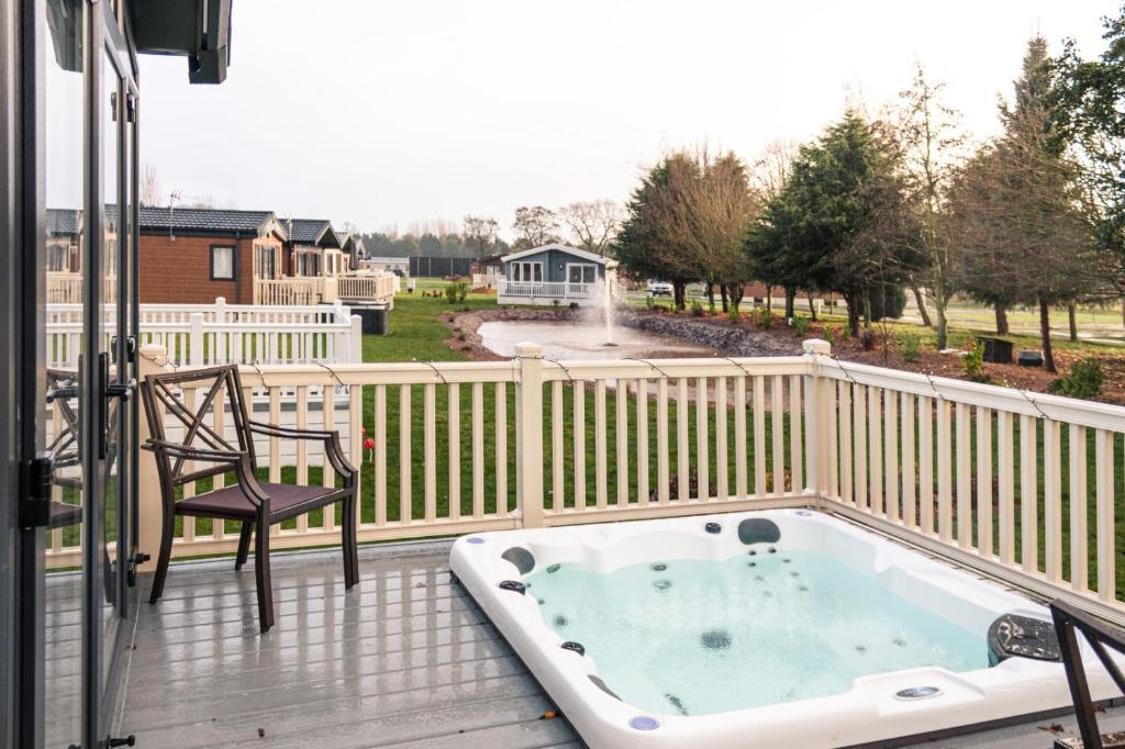 een hot tub op een terras met een stoel bij JJs Lodge Lakewood in York