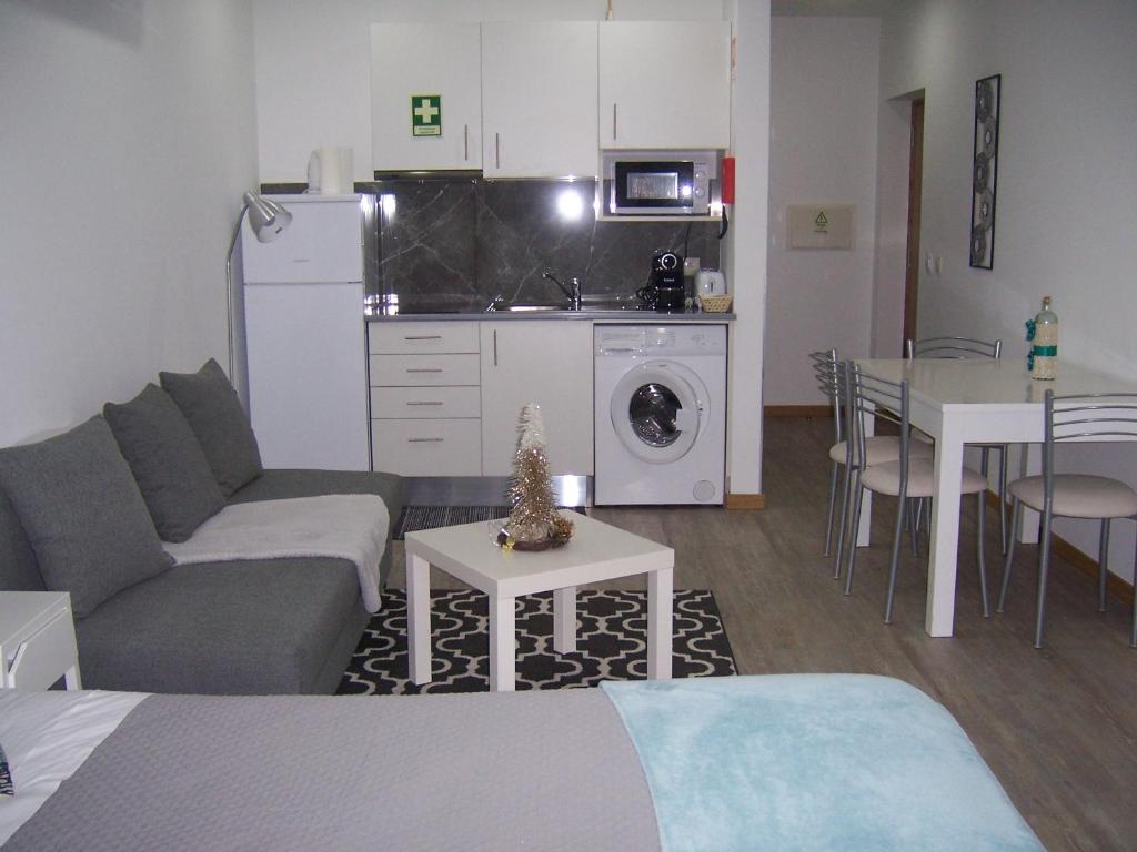 uma sala de estar com um sofá, uma mesa e uma cozinha em NC Apartamentos em Brangança