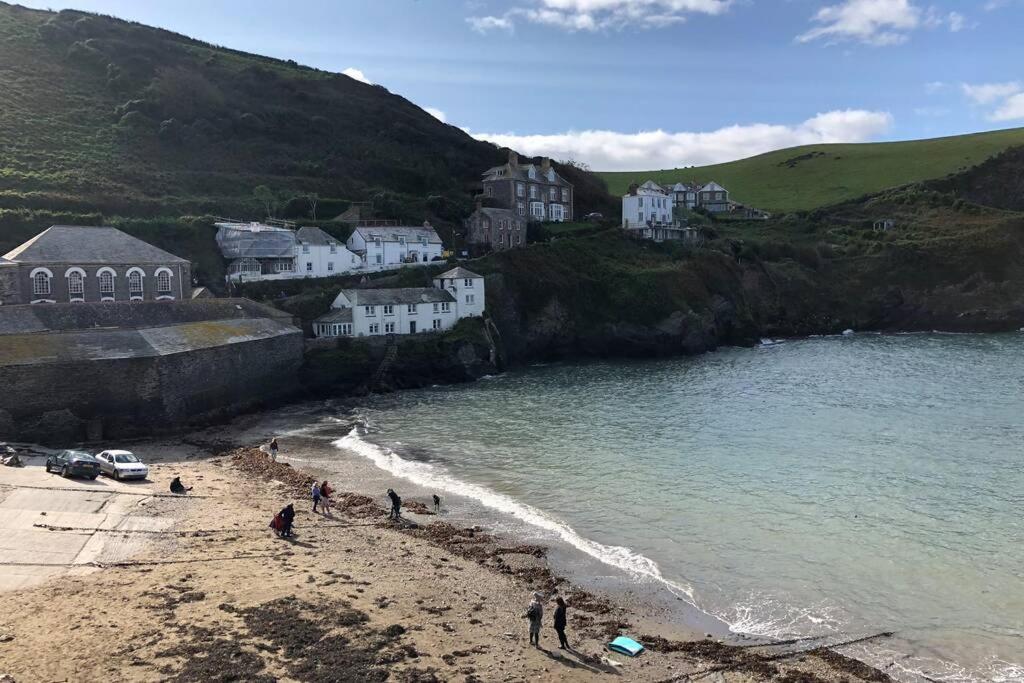a group of people on a beach near the water at Molls Yard Traditional Cottage in Port Isaac