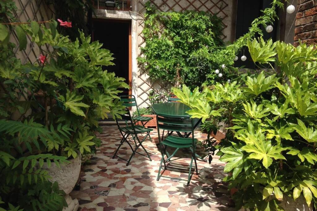 un patio con sillas, mesa y plantas en A PRIVATE TERRACE IN THE HEART OF VENICE, en Venecia