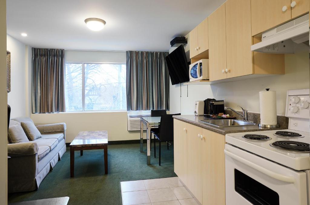 a kitchen and living room with a couch and a table at The Business Inn in Ottawa