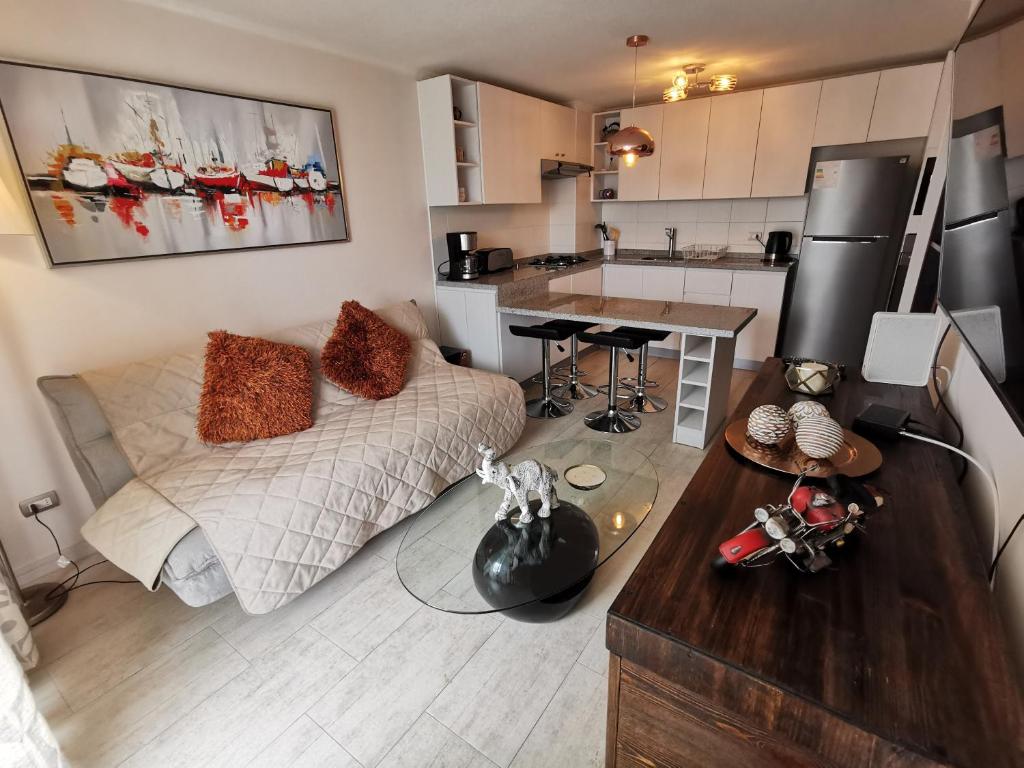 a living room with a bed and a kitchen at Departamento en Avenida Del Mar in La Serena