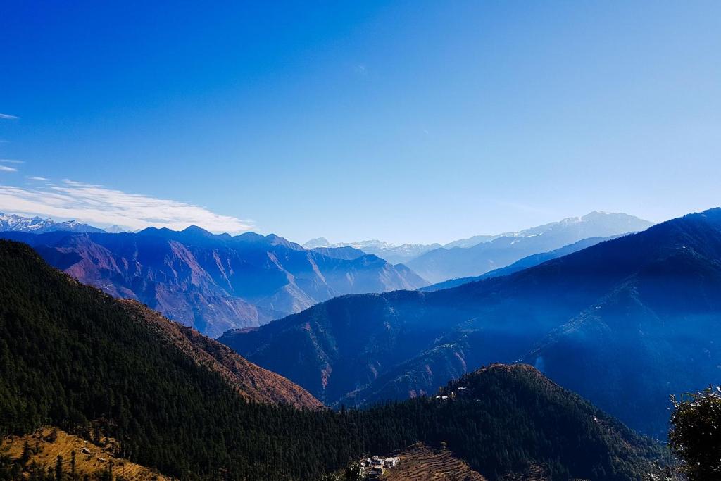 uma vista para um vale montanhoso com florestas e montanhas em Grand Kailash Khajjiar em Dalhousie