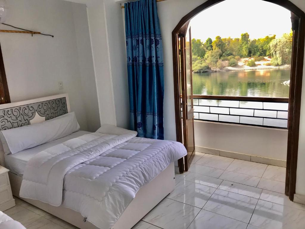 a bedroom with a bed and a large window at NOBATiA Guest House in Aswan