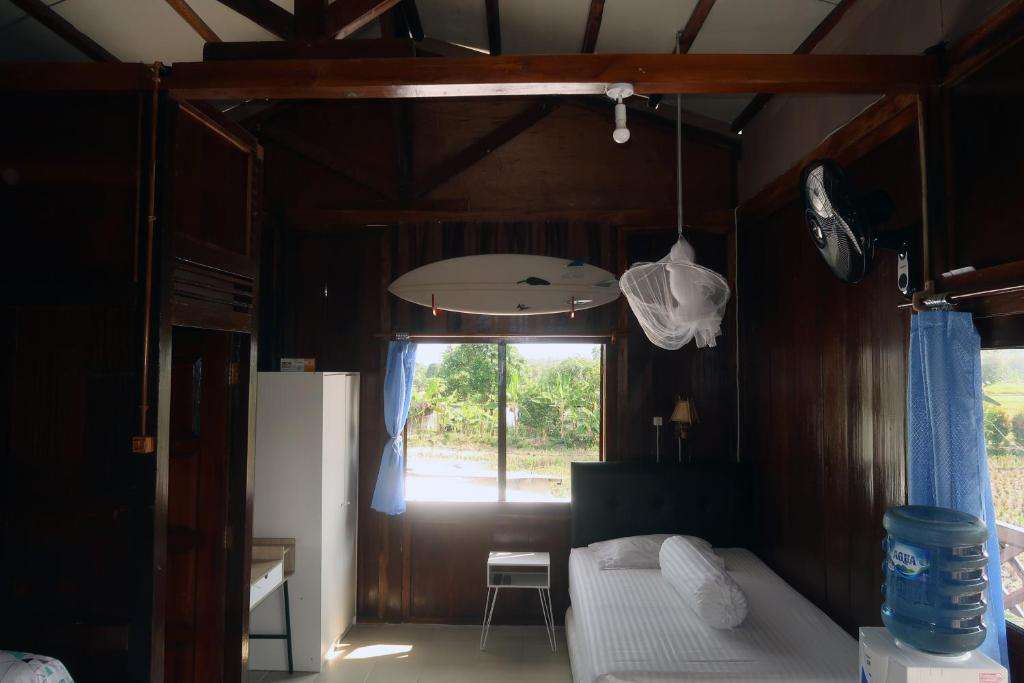 a small room with a bed and a window at Arya's Surf Camp in Sukabumi