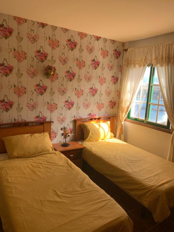 a hotel room with two beds and a window at Apartamento Mar y Montaña in Los Silos