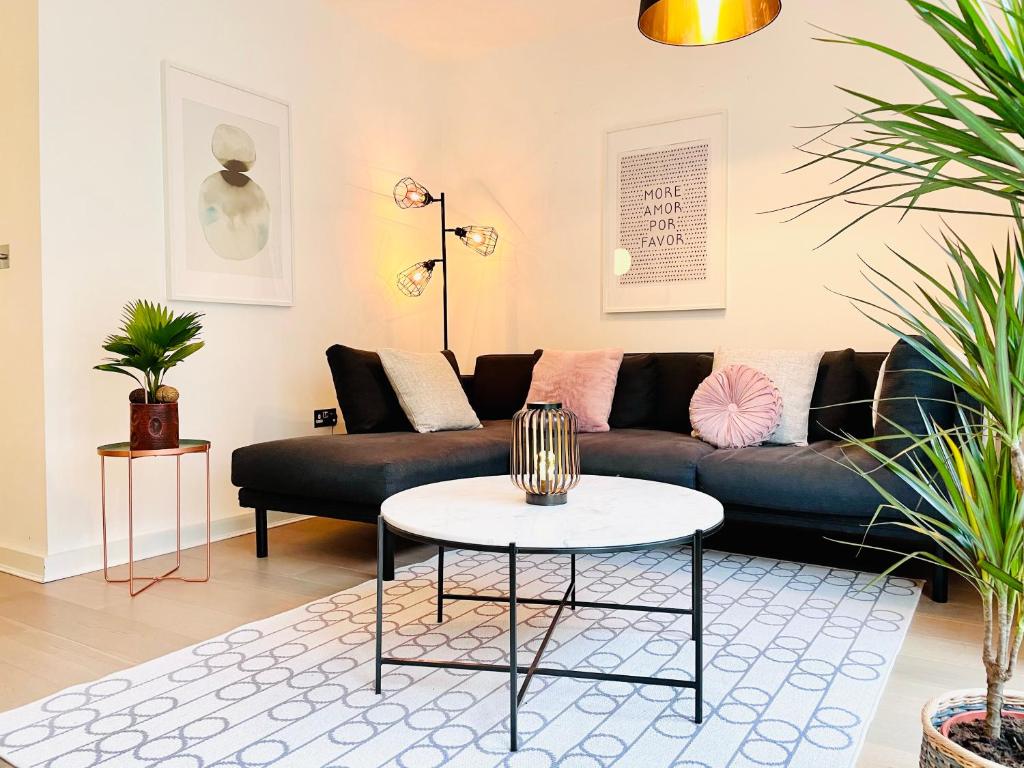 a living room with a couch and a table at Olympic Family Home, With Own Garden Bliss in London