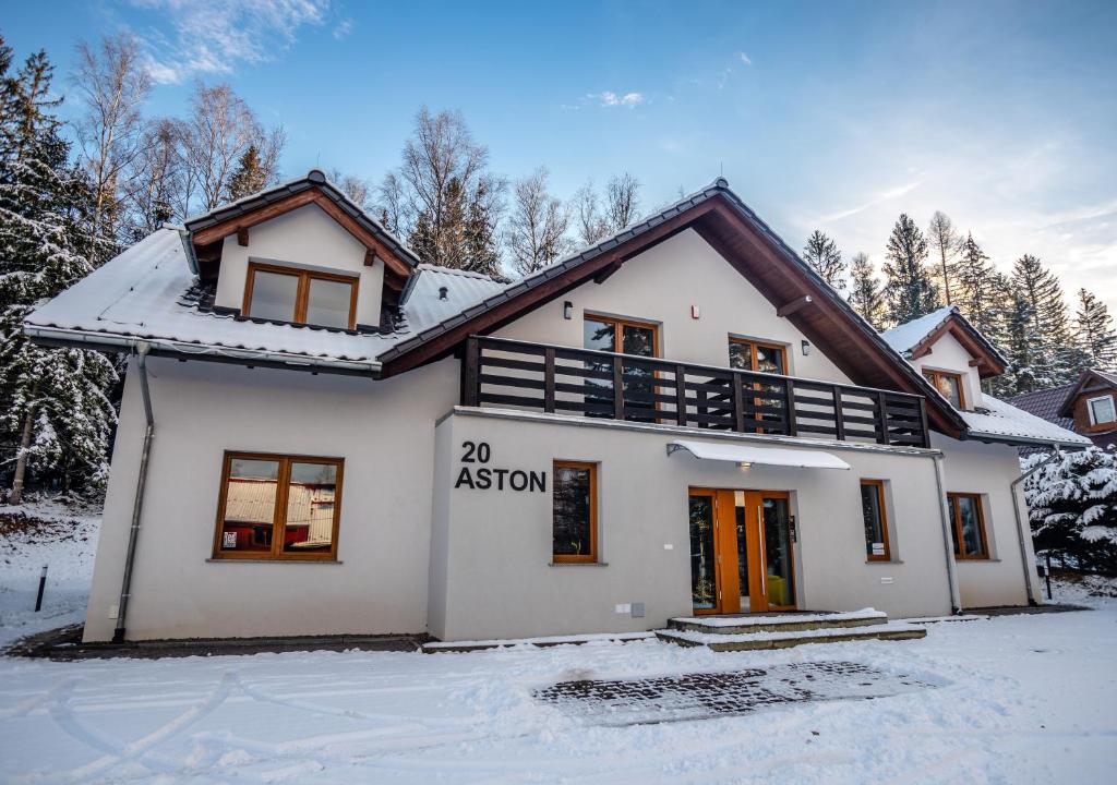 a house with a agent sign on it in the snow at Aston -domek przy lesie, przestronny in Karpacz