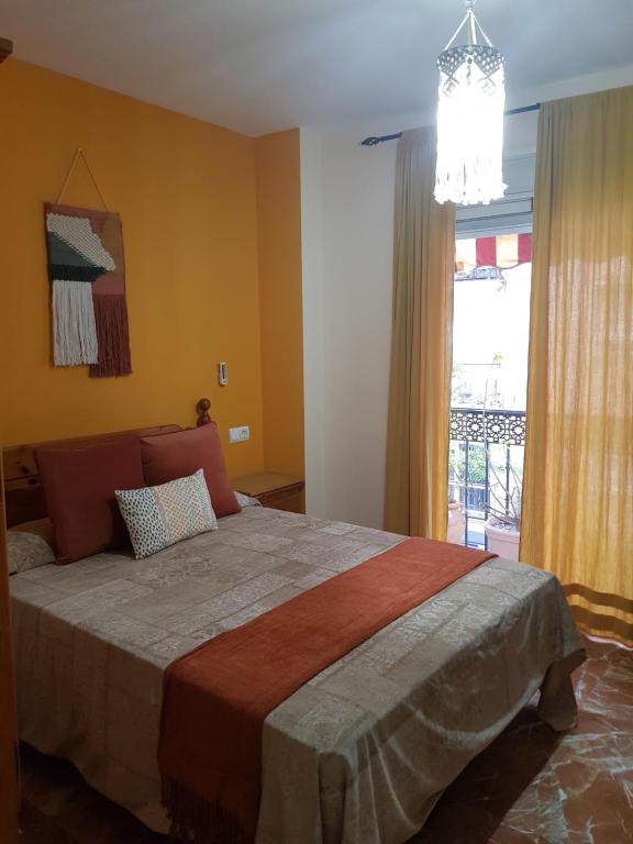 Un dormitorio con una cama grande y una ventana en Pension La Vega en Huelva