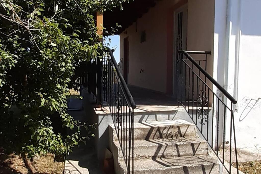 un conjunto de escaleras que conducen a una casa con dos bancos en Happy Days Villa, en Leptokarya