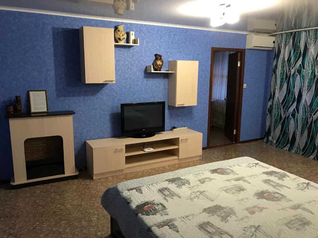 Tuymazyにあるtwo-room apartments on Lenin 19 avenueの青い壁のベッドルーム(テレビ付)