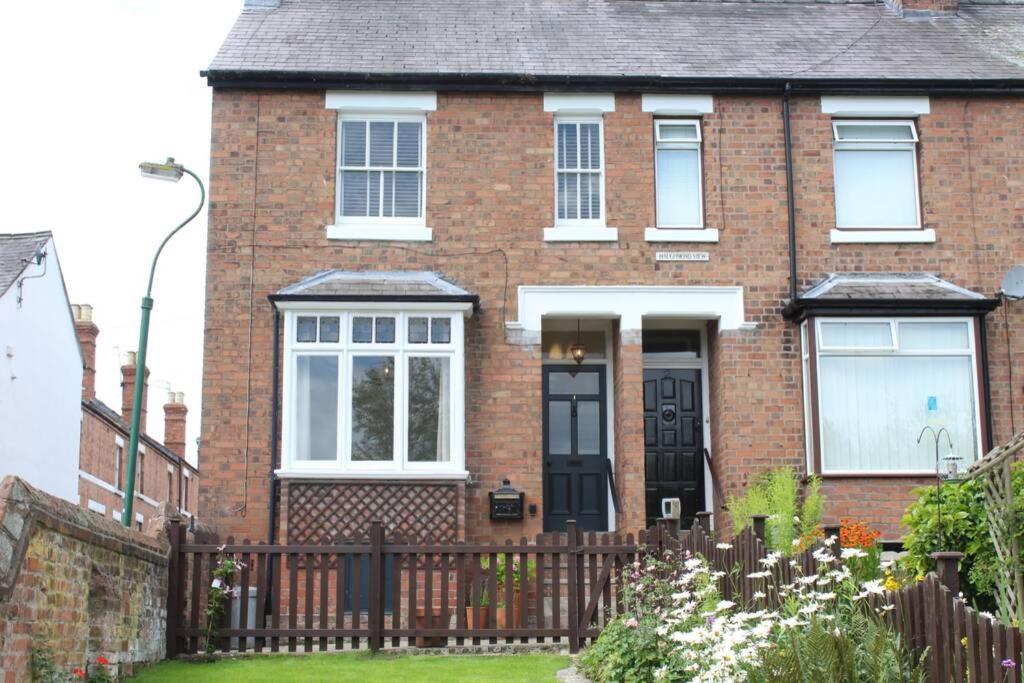 een rood bakstenen huis met een zwart hek bij Luxury townhouse in town centre, views, river walk in Shrewsbury