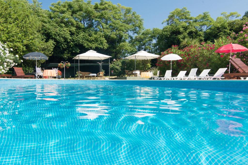 een groot zwembad met stoelen en parasols bij Villa Anna in Savudrija