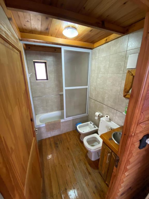 Baño pequeño con aseo y lavamanos en Cabañas Los Álamos en Villa Carlos Paz