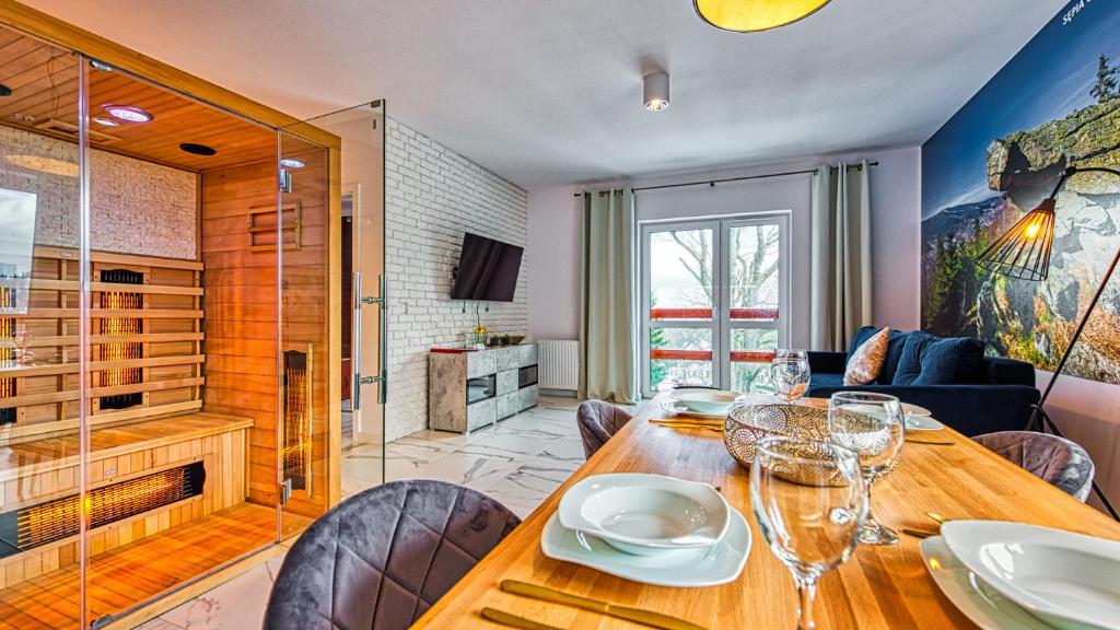 ein Esszimmer mit einem Holztisch und Stühlen in der Unterkunft Apartament Sępia Góra Premium z Sauną - 5D Apartamenty in Świeradów-Zdrój