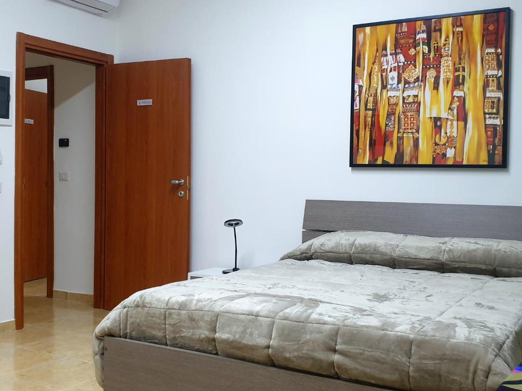1 dormitorio con 1 cama y una pintura en la pared en B&B HERCULANEUM RUINS en Ercolano