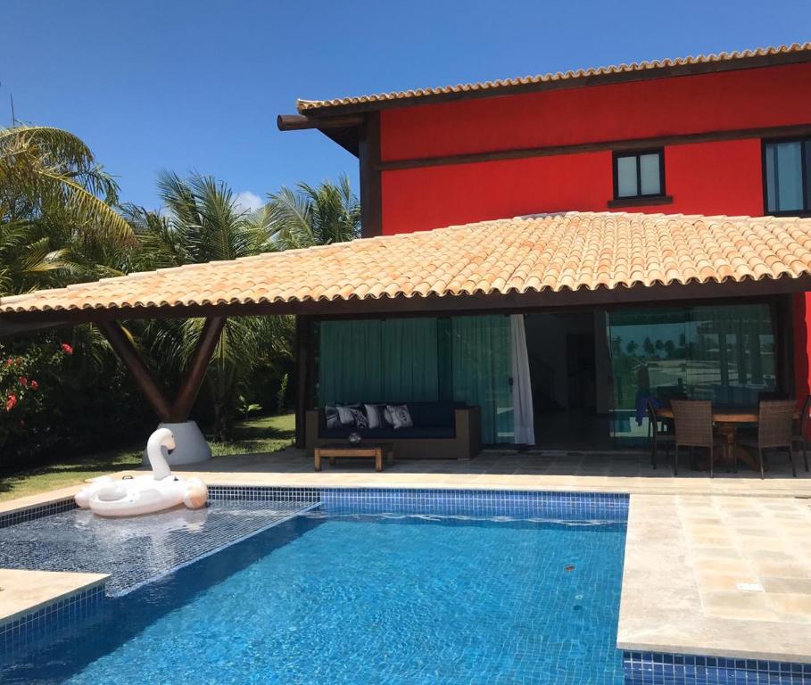 una piscina di fronte a una casa con un resort di CASA CONDOMÍNIO IBEROSTATE - RESORT IBEROSTAR a Praia do Forte