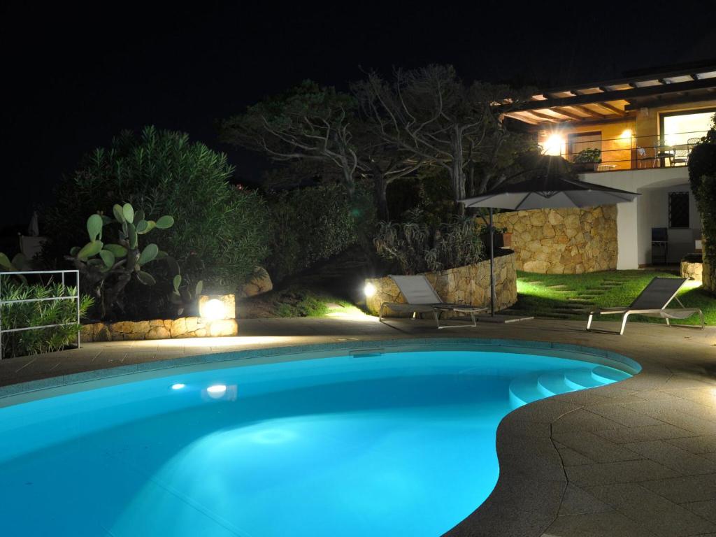 basen w ogrodzie w nocy w obiekcie Villa with a swimming pool, overlooking the crystal-clear waters of the Costa Smeralda w mieście Porto Cervo