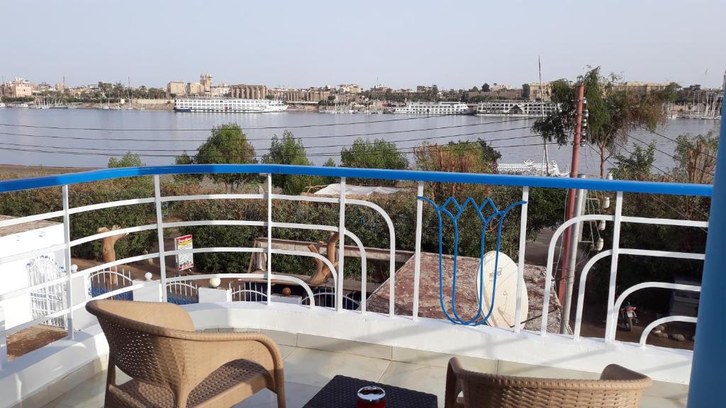 einen Balkon mit einem Tisch und Stühlen auf einem Boot in der Unterkunft Hofni Palace Nile Niew in Luxor
