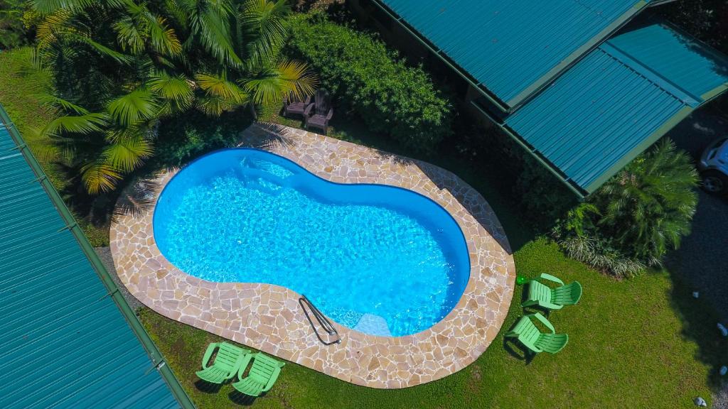 an overhead view of a swimming pool with chairs and palm trees at Forest Lodge in Uvita