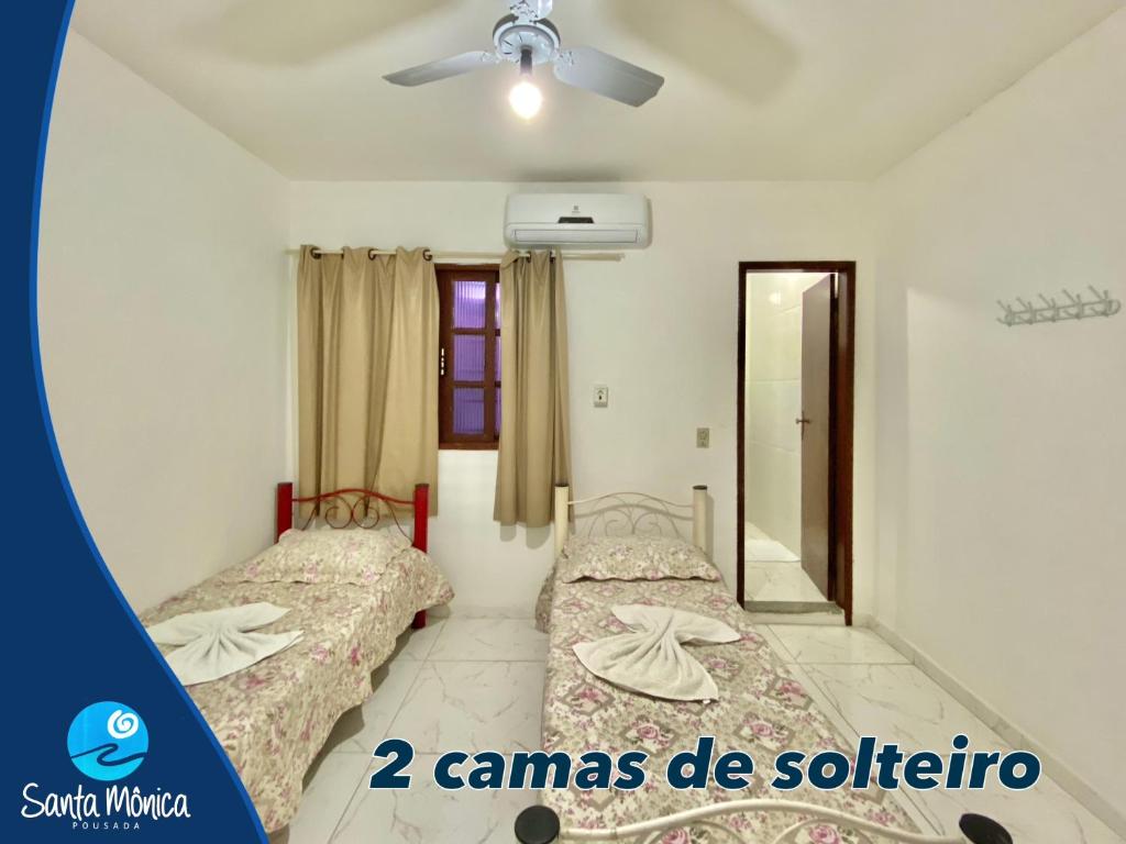 1 dormitorio con 2 camas y ventilador de techo en Pousada Santa Monica, en Guarapari