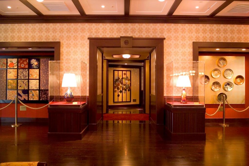 a room with two tables with vases on them at Kanazawa Hakuchoro Hotel Sanraku -Natural Hot Spring- in Kanazawa