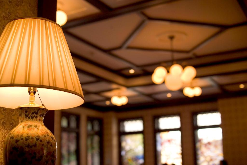 a lamp on a wall in a room with windows at Kanazawa Hakuchoro Hotel Sanraku -Natural Hot Spring- in Kanazawa