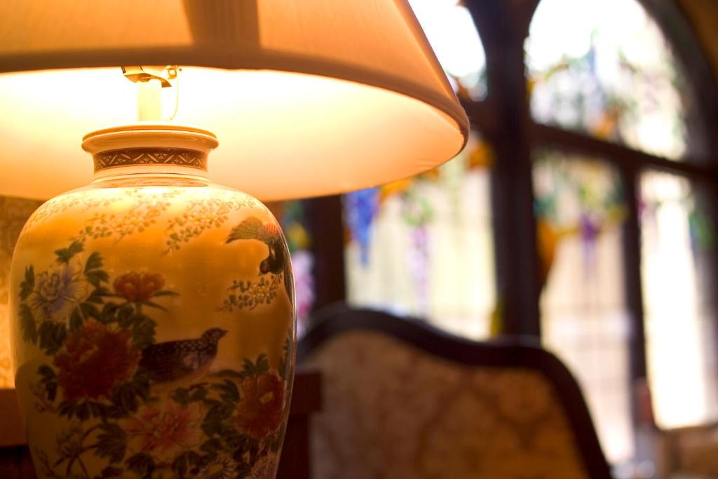 a vase sitting on a table with a lamp at Kanazawa Hakuchoro Hotel Sanraku -Natural Hot Spring- in Kanazawa