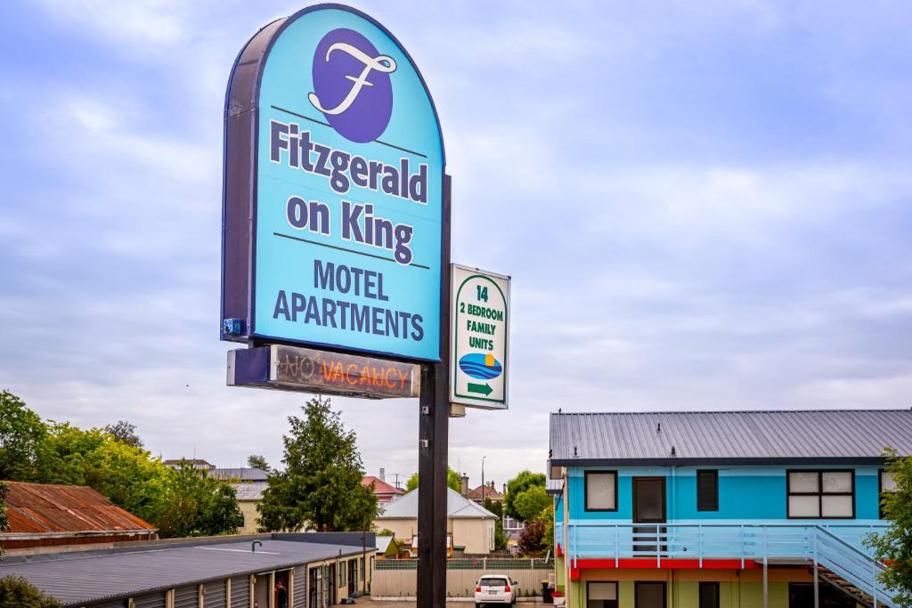 a sign for a hotel in a parking lot at Fitzgerald on King in Timaru