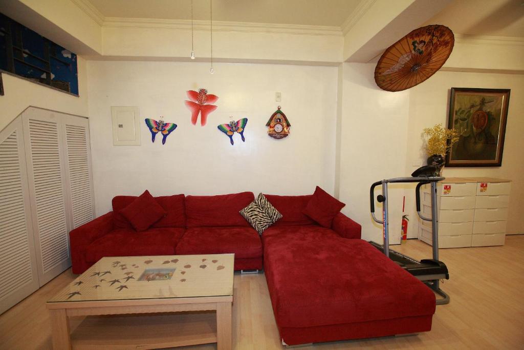 a living room with a red couch and a table at Cruise Homestay in Hualien City