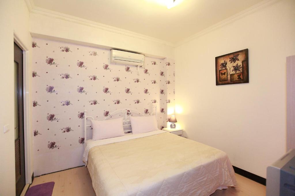 a bedroom with a bed and a wall with flowers at Cruise Homestay in Hualien City