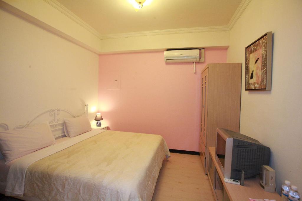 a bedroom with a bed and a tv at Cruise Homestay in Hualien City