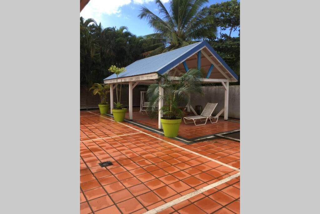 une maison avec une véranda et un patio en briques dans l'établissement La Martinique vous tend les bras !, au Diamant
