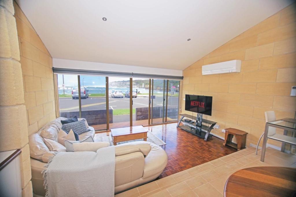 a living room with a white couch and a tv at Bayview no 2 in Port Campbell