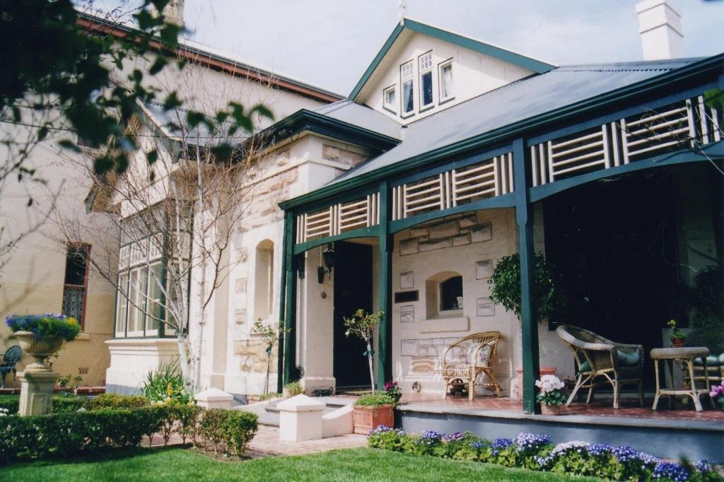 uma casa antiga com um alpendre e um pátio em Water Bay Villa Bed & Breakfast em Adelaide