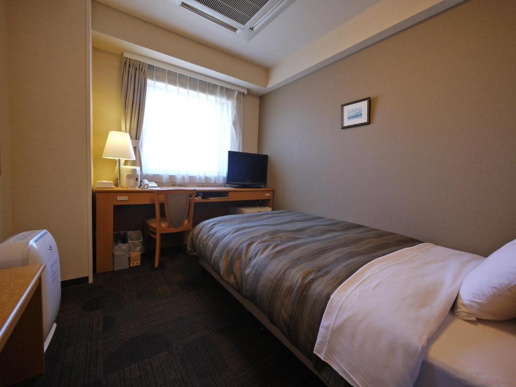 Llit o llits en una habitació de Hotel Route-Inn Sapporo Shiroishi