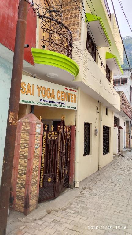 un bâtiment avec un panneau indiquant le centre de yoga sal dans l'établissement Yogi Home Stay, à Rishikesh