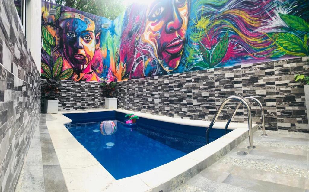 ein Pool mit einem Gemälde an der Seite eines Gebäudes in der Unterkunft Hermosa Habitación cerca al Centro histórico in Cartagena de Indias