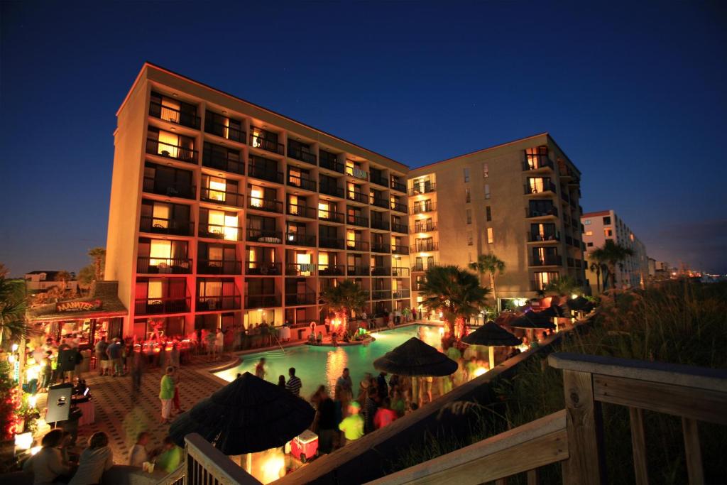un hotel con piscina di notte di Wyndham Garden Fort Walton Beach Destin a Fort Walton Beach