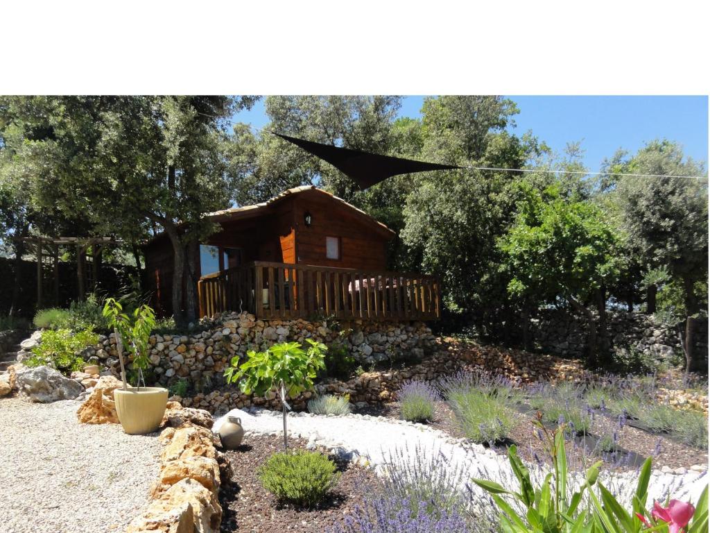 a garden with a log cabin in the background at Domaine de la Borie in Trans-en-Provence