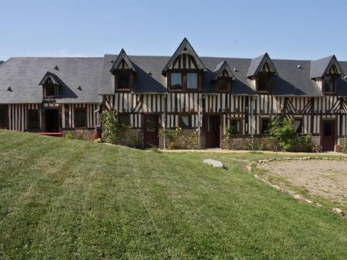uma casa grande com um campo de relva em frente em Les Chambres de Pontfol - Chambres d'hôtes - Guest house em Victot-Pontfol