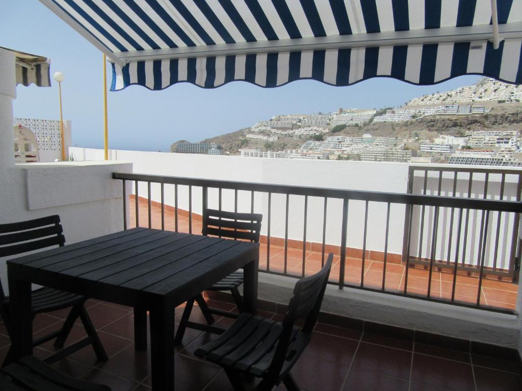 a table and chairs on a balcony with a view at Vista Playa in Mogán