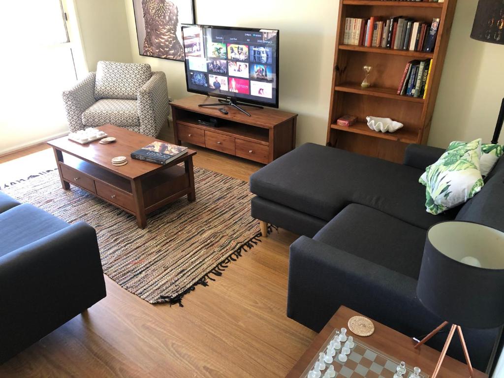 a living room with a couch and a tv at 225 on Myall in Tea Gardens